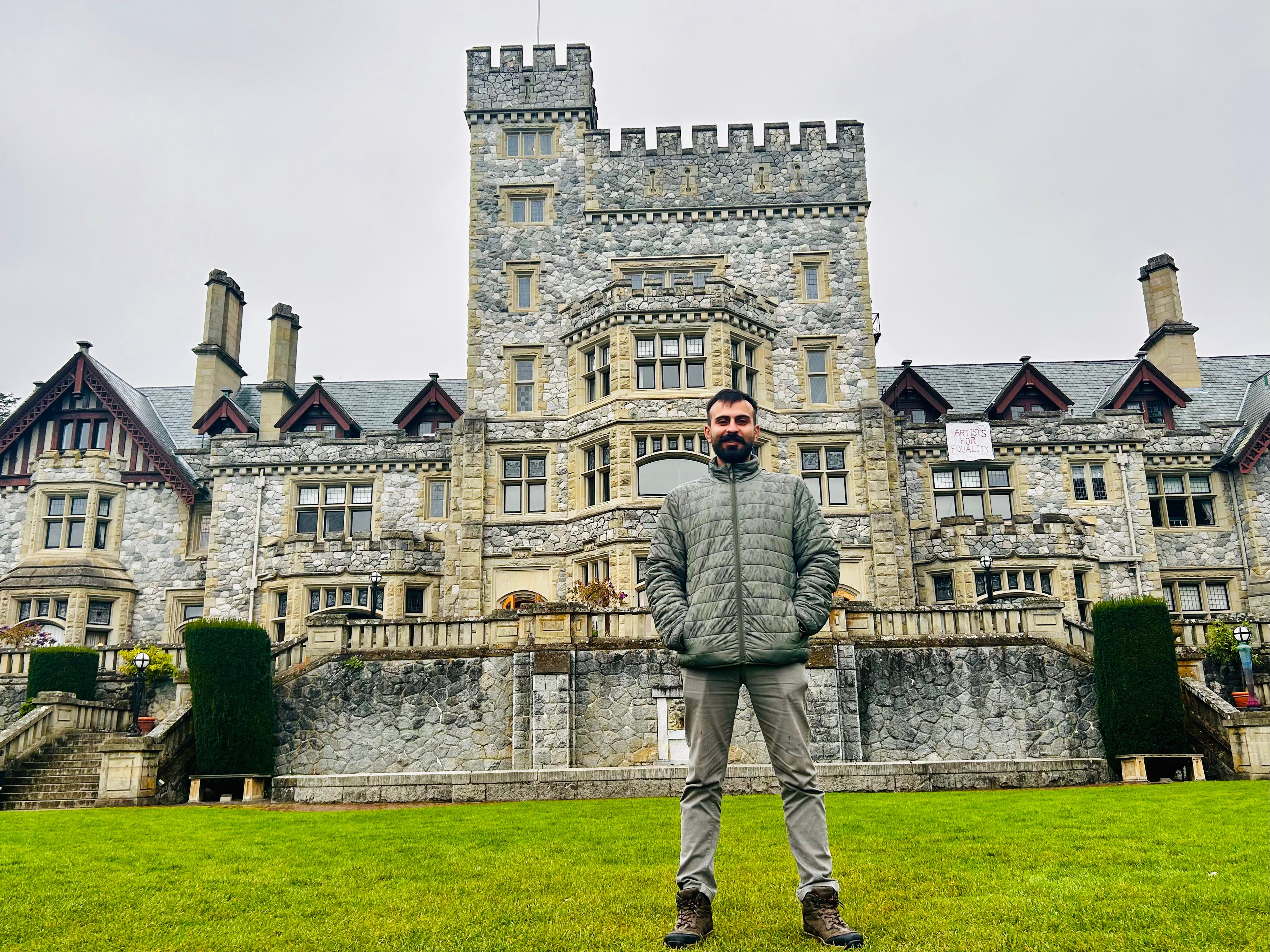 Salman Haider standing in front of a castle-style stone building