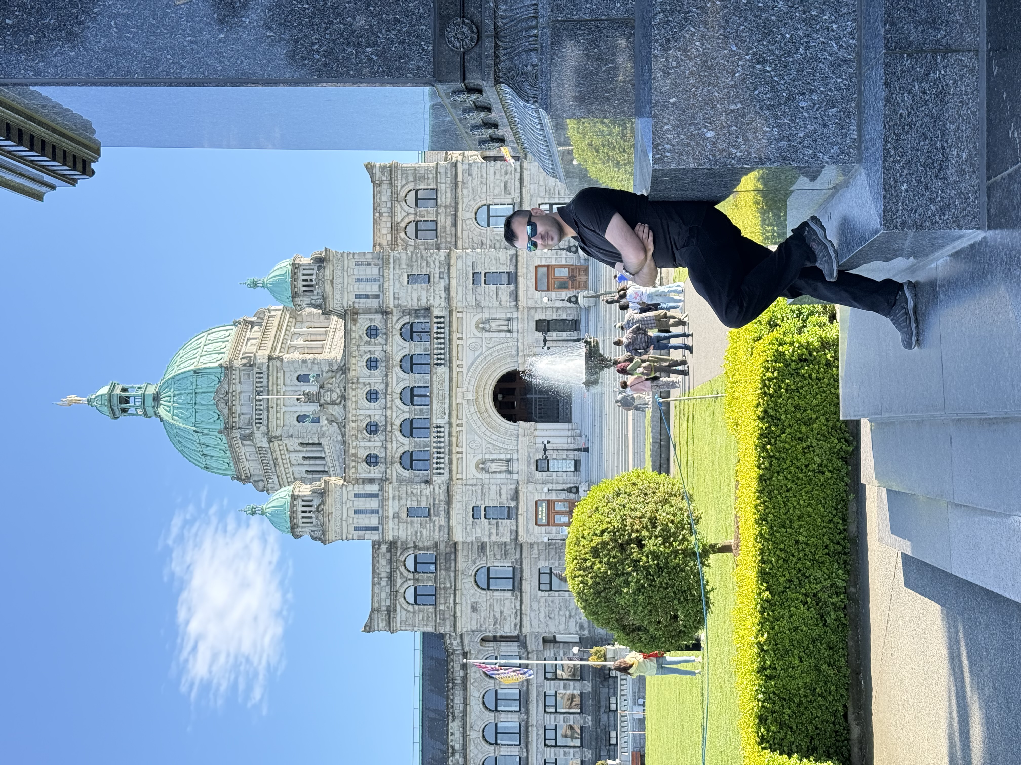 Salman Haider sitting near the British Columbia Parliament Buildings