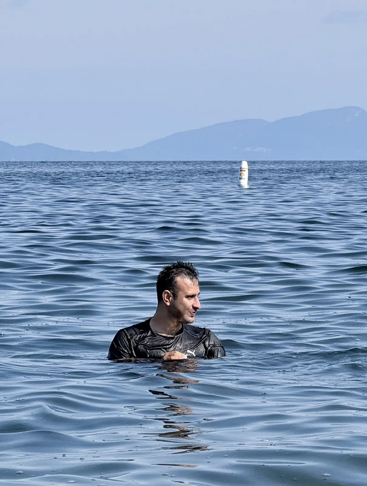 Salman Haider in open water with mountains in the background