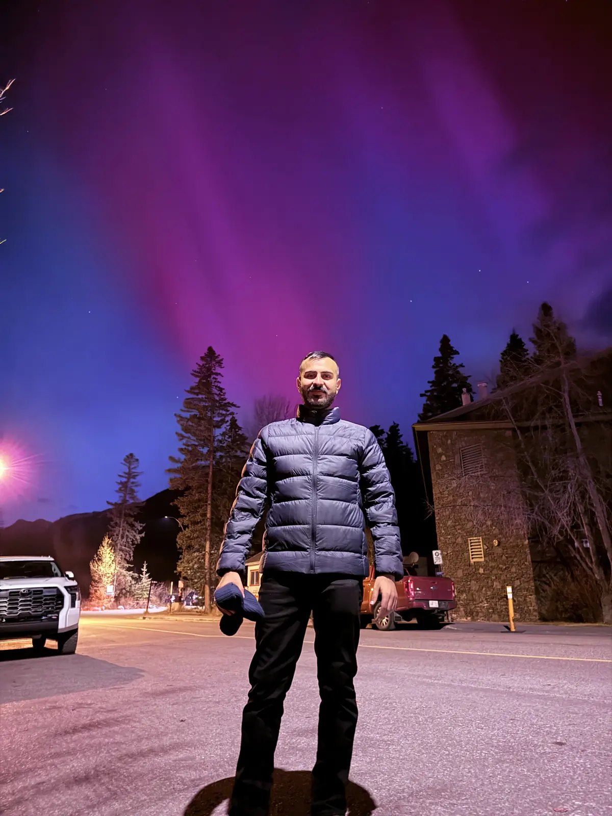 Salman Haider standing under northern lights at night